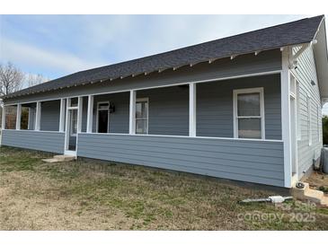 Charming home featuring a covered porch with white pillars and gray siding at 135 Waycross Dr, Rockwell, NC 28138