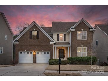 Charming two-story brick home featuring a two-car garage and inviting front entrance at 14104 Green Birch Dr, Pineville, NC 28134