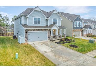 Charming two-story home featuring a stone-accented facade, attached two-car garage and a well-manicured lawn at 4849 Tacoma Dr, Fort Mill, SC 29707
