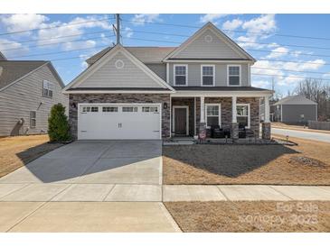 Charming two-story home with a stone and siding facade, two car garage and a well-maintained front yard at 7019 Lenton Rd, Charlotte, NC 28215