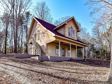 Two-story house with red roof, large windows, and porch at 730 High Rock Crusher Rd, Wadesboro, NC 28170