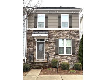 Charming townhome with a stone facade and decorative shutters, well-manicured landscaping at 11724 Blessington Rd, Huntersville, NC 28978