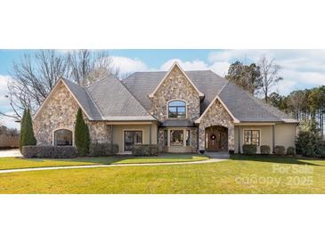 Stone-accented home showcasing a well-manicured lawn, mature trees, and a welcoming facade at 148 Castle Dr, Mooresville, NC 28117