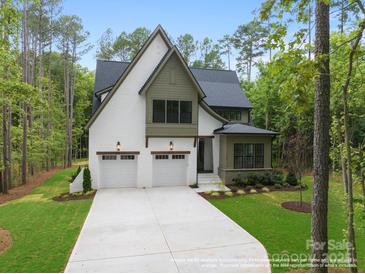 Beautiful two-story home featuring a white facade, a two-car garage and lush green landscaping at 19155 Newburg Hill Rd, Davidson, NC 28036