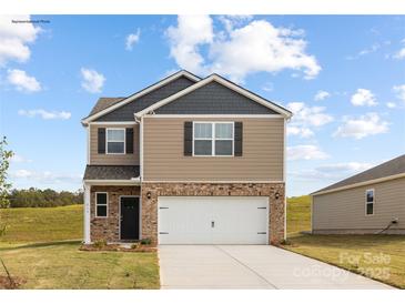 Charming two-story home featuring a brick and siding exterior, attached two-car garage, and a well-manicured lawn at 321 Brinkley Dr # 106, Kings Mountain, NC 28086