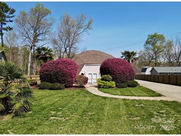Charming home with a unique design and beautifully landscaped front yard featuring vibrant bushes at 7977 Lucky Creek Ln, Denver, NC 28037