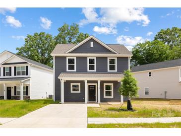 Charming two-story home with gray siding, white trim, a cozy front porch, and inviting curb appeal at 1124 Thayer Glen Ct, Charlotte, NC 28213
