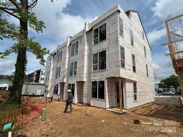 New construction three-story townhome showcases modern architecture with large windows and durable exterior materials at 115 Verbena Ne St # 12, Charlotte, NC 28217