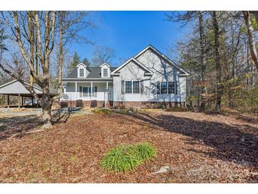 Charming single Gathering home with a covered porch and a well-maintained front yard and a carport at 1745 Badin Lake Rd, New London, NC 28127