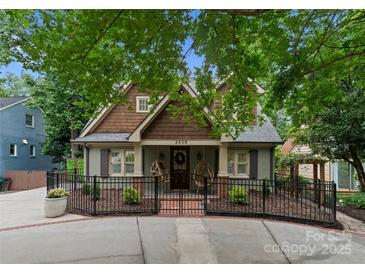 Charming two-story home with updated façade and landscaping, complemented by a stylish black fence and inviting front porch at 2809 Glendale Rd, Charlotte, NC 28209