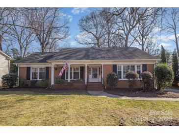 Charming single-story brick home with a cozy front porch and well-maintained landscaping at 4001 Glenfall Ave, Charlotte, NC 28210