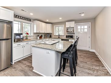 Bright, open kitchen with white cabinets, stainless steel appliances, and an eat-in island at 7514 Highway 205 Hwy, Marshville, NC 28103