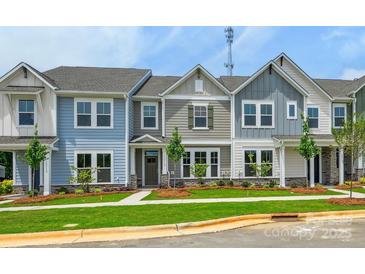 Charming townhome with a well-manicured lawn, colorful facade, and inviting curb appeal at 10115 Mamillion Dr, Huntersville, NC 28078