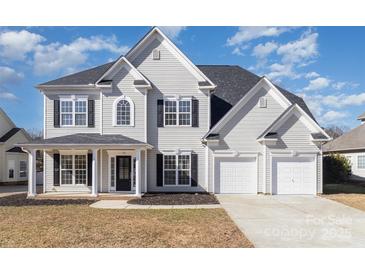 Traditional two-story home with a three-car garage, black shutters and inviting front porch at 132 Elizabeth Hearth Rd, Mooresville, NC 28115