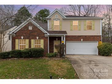 Charming two-story home featuring a brick facade, light yellow shutters, and a well-maintained front yard at 3302 Cole Mill Rd, Charlotte, NC 28270