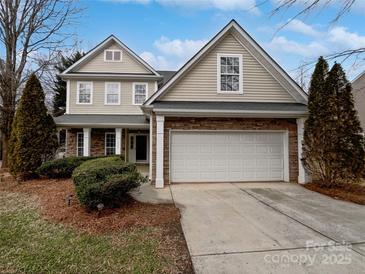 Two-story house with beige siding, stone accents, and a two-car garage at 2507 Oakdale Creek Ln, Charlotte, NC 28216