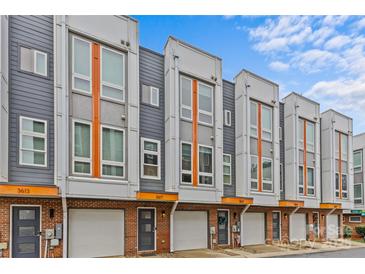 Modern townhome exterior featuring a brick facade, gray siding, and large windows under a blue sky at 3617 Vallette Ct, Charlotte, NC 28203