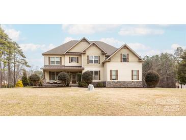 Charming two-story home featuring a well-manicured lawn, neutral siding and complementing dark shutters at 712 Kenway Loop, Mooresville, NC 28117