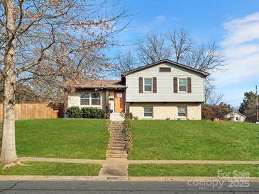 Charming two-story home with manicured lawn, and a lovely bright orange front door at 7131 Thorncliff Dr, Charlotte, NC 28210