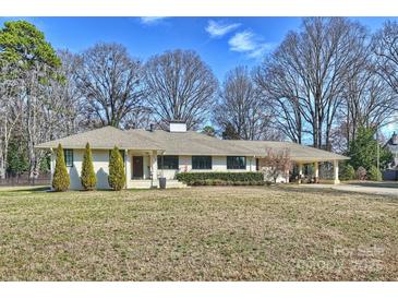 Charming single-story home with well-maintained lawn and mature trees offers picturesque curb appeal at 2100 Sunderland Pl, Charlotte, NC 28211