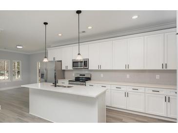 Modern kitchen with stainless steel appliances, a center island with seating, and white cabinets with sleek black hardware at 2365 Kool Park Ne Rd, Hickory, NC 28601