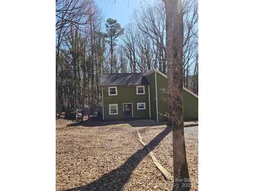 View of the exterior of the home featuring a wooded lot at 4125 Rivendell Ln, Mint Hill, NC 28227