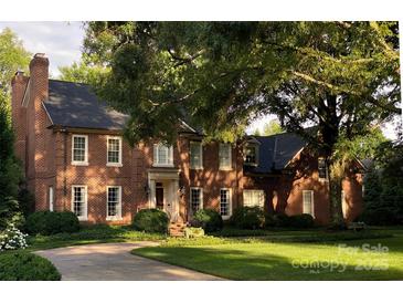 Stately brick home with manicured lawn, mature trees and circular driveway at 641 Museum Dr, Charlotte, NC 28207