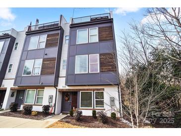 Modern townhome featuring a striking facade with mixed materials and a rooftop deck, enhancing its urban appeal at 7020 Loso Commons Way, Charlotte, NC 28217