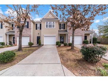 Charming townhome featuring a one-car garage, driveway, and well-maintained landscaping at 7719 Abigail Glen Dr, Charlotte, NC 28212
