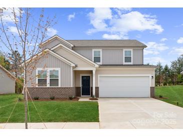 Charming two-story home boasts a manicured lawn and attached two-car garage, perfect for families seeking comfort and style at 821 Hallman Branch Ln, Lincolnton, NC 28092