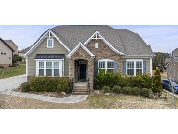 Charming home featuring a stone facade, complemented by lush landscaping and neutral toned siding at 11223 Wescott Hill Dr, Huntersville, NC 28078