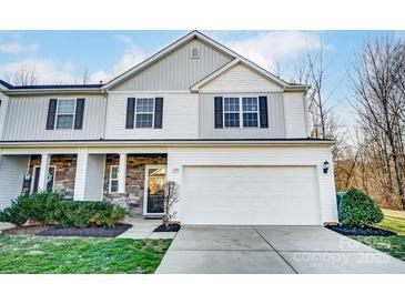 Charming two-story home with a two-car garage, stone accents, manicured lawn and inviting entryway at 129 Woodbridge Cir, Mount Holly, NC 28120