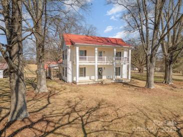 Charming two-story home with a red roof, a double porch, and mature trees at 202 Deitz Rd, Statesville, NC 28625