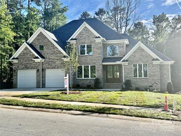 Attractive brick home with a two-car garage, manicured lawn, and large windows, creating curb appeal at 2418 Lexington Approach Dr, Charlotte, NC 28262