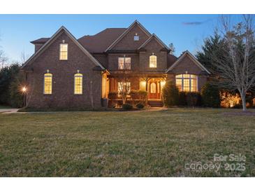 Charming brick two-story home with a beautifully landscaped front yard and inviting front porch at 2553 Cozy Cove Dr, York, SC 29745