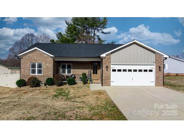 Charming brick home with a two-car garage, landscaped yard, and a welcoming front porch at 5324 Stonewood Dr, Hickory, NC 28602