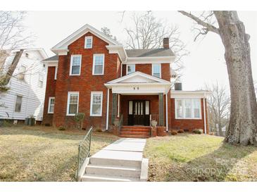 Classic brick home with a welcoming front porch and well-maintained lawn at 55 Academy Nw Ave, Concord, NC 28025