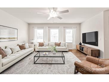 Bright living room with hardwood floors, plush rug, and modern furnishings at 8500 Union Central Ct, Waxhaw, NC 28173