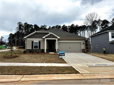 Charming single-story home boasts a welcoming facade, attached garage, and well-manicured landscaping at 1401 Windy Park Dr, Stanley, NC 28164