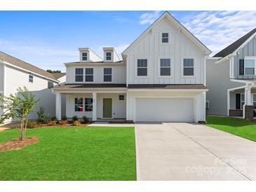 Charming two-story home boasts a well-manicured lawn, a classic white facade, and a welcoming green front door at 163 Stonewater Dr # 4P, Red Cross, NC 28129