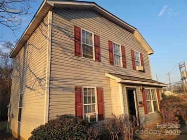 Charming two-story home featuring red shutters and a well-maintained, landscaped front yard, offering great curb appeal at 609 Billingsley Rd, Charlotte, NC 28211