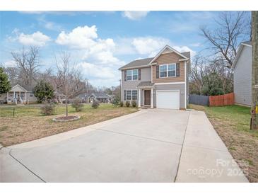 Charming two-story home features a long driveway and an attached garage at 610 John St, Monroe, NC 28110