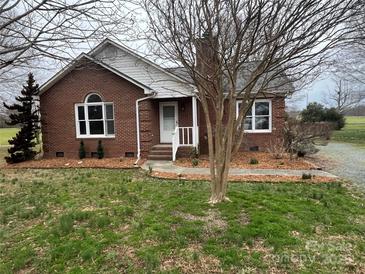 Charming brick home featuring a manicured front lawn and a welcoming entrance at 6901 Green Haven Ln, Monroe, NC 28110