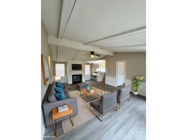 Open-concept living room featuring a modern fireplace, neutral tones, and seamless flow to the kitchen at 1718 Fallston Rd, Shelby, NC 28150