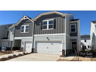 Charming two-story home with attached garage, modern siding, and manicured front lawn in a cozy neighborhood at 1735 Braemar Village Dr, Monroe, NC 28110