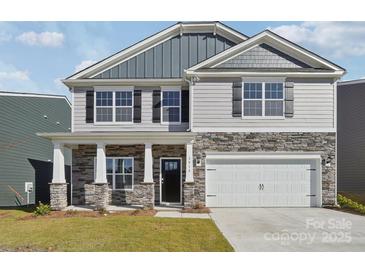Two-story home featuring gray siding, stone accents, black shutters, and an attached two-car garage at 2323 Riggs Rd, Sherrills Ford, NC 28673