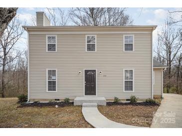 Two-story home featuring neutral siding, a dark front door, and a simple walkway leading to the entrance at 8137 Sheringham Way, Charlotte, NC 28227