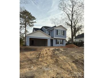 Charming two-story home with blue siding and black shutters, attached two-car garage on a large lot at 207 Wylie St # 3, Lancaster, SC 29720