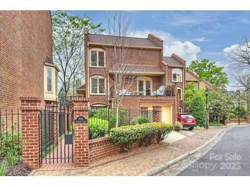 Charming brick townhome featuring a gated entrance, balcony, and a one-car garage, nestled in a desirable community at 309 Settlers Ln, Charlotte, NC 28202