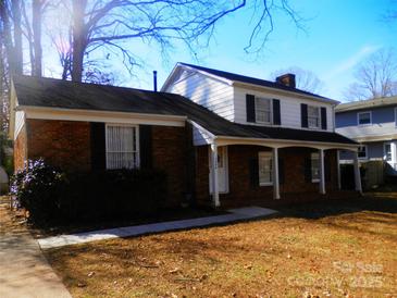 Charming two-story home with a brick facade, black shutters and a well-maintained lawn at 3406 Erinbrook Ln, Charlotte, NC 28215